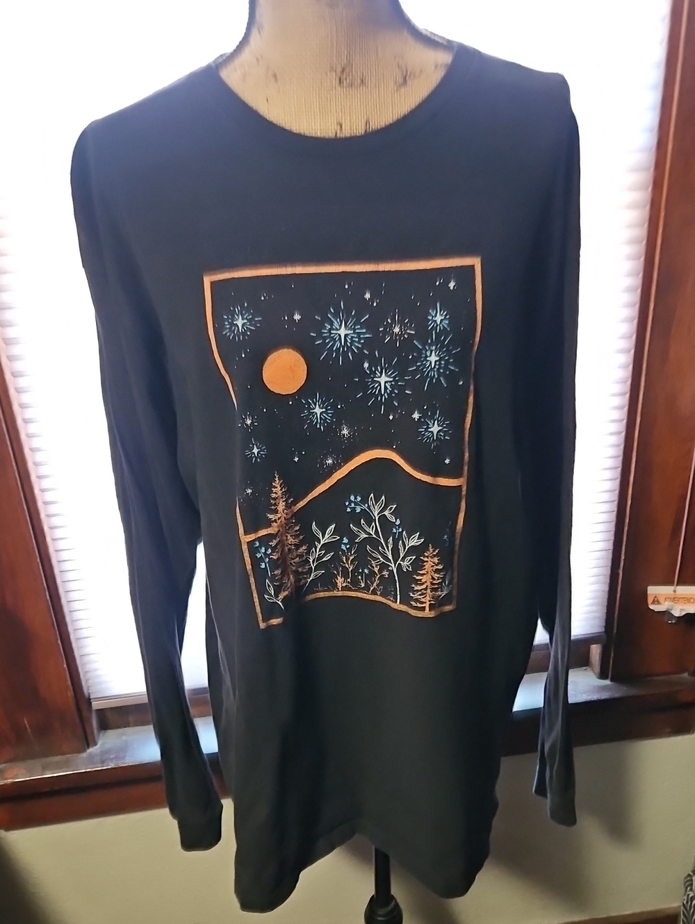Black Long-Sleeve Graphic Tee with Orange Moon and Blue Starburst Design